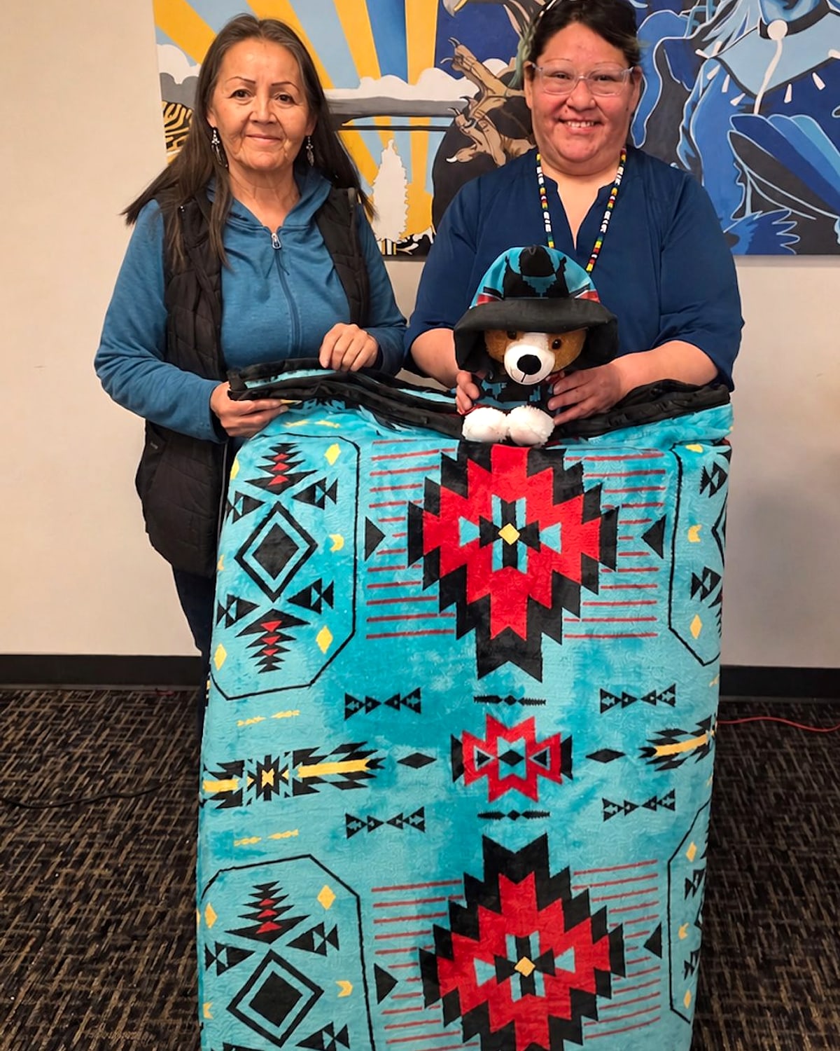 Hayley and Bonita presenting a turquoise handmade Imitah dog bed