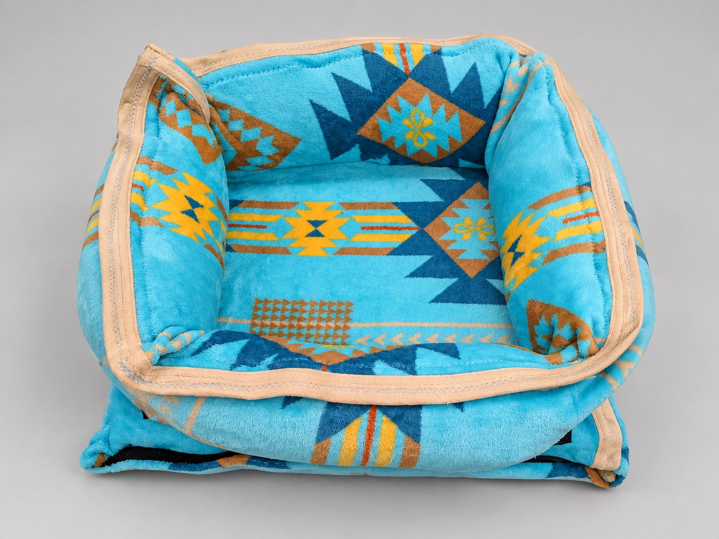 Small Donut Imitah bed with turquoise geometric fabric, tan trim, and padded sides